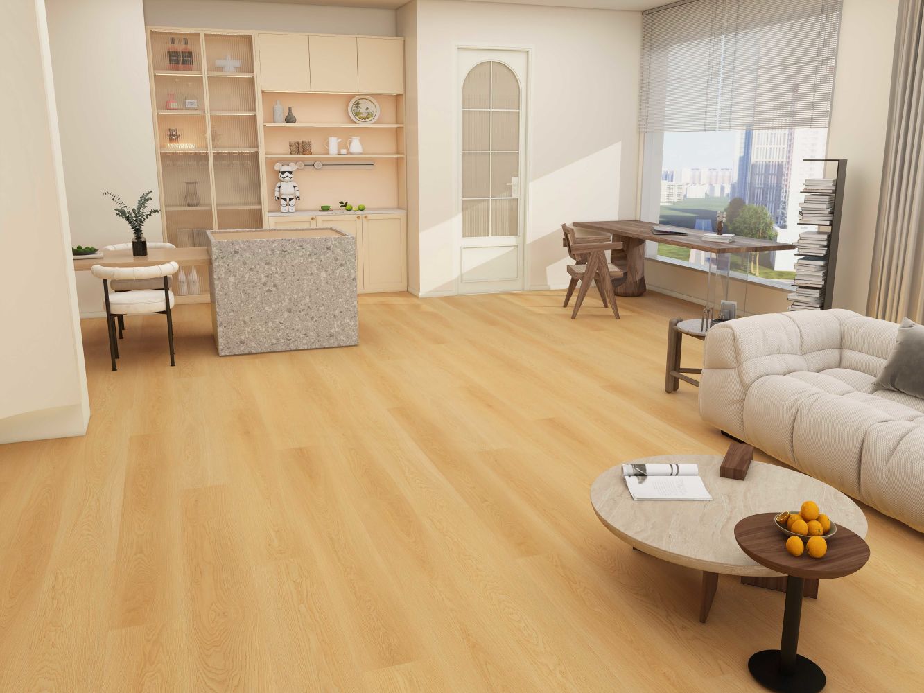 Open-concept living room with a light wood floor, cream sofa, round coffee tables with a bowl of oranges, and a work desk near a large window.